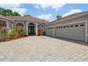 Beautiful home featuring manicured landscaping, a brick driveway, and a spacious three-car garage at 1542 Wescott Loop, Winter Springs, FL 32708