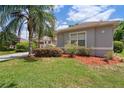 Landscaped yard with green grass, a palm tree and a neatly maintained garden bed at 1542 Wescott Loop, Winter Springs, FL 32708