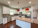 Beautiful kitchen features white cabinets, stainless appliances, granite countertops, and island at 1546 Water Elm Ct, Orlando, FL 32825