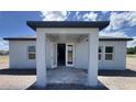 Rear of home showcasing a covered entrance with windows and neutral color scheme at 1635 Cane Bamboo Drive, St Cloud, FL 34771