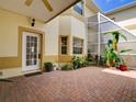 Enclosed patio with brick flooring, tropical plants and a ceiling fan for relaxation at 17322 Chateau Pine Way, Clermont, FL 34711