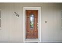 A solid wood front door with glass insert greets visitors to this charming home at 209 7Th S St, Haines City, FL 33844