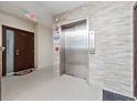 Elevator lobby with an exit sign, elevator, and brick textured walls at 2121 Hill St # 7B, New Smyrna Beach, FL 32169