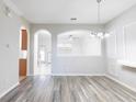 Bright, open-concept living area with arched openings and wood flooring at 2211 J Lawson Blvd, Orlando, FL 32824