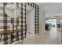 Stylish entryway with black and white checkered wallpaper, a round mirror, and contemporary console table at 2438 Dubai St, Kissimmee, FL 34747