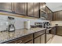 Updated kitchen featuring stainless steel appliances, granite countertops, and dark wood cabinets with ample storage at 2438 Dubai St, Kissimmee, FL 34747