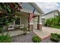 Inviting front porch featuring cozy seating and decorative stone columns, creating a warm and welcoming entrance at 3142 Dark Sky Dr, Harmony, FL 34773