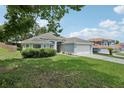Lovely single-story home featuring lush green lawn, mature trees, and an attached two-car garage at 3326 Sassaquin Ct, Orlando, FL 32818
