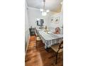Dining room with hardwood floors and table set for four with elegant chandelier at 3379 S Kirkman Rd # 1027, Orlando, FL 32811