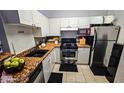 Efficient kitchen design with stainless steel appliances, white cabinetry, and granite countertops at 3379 S Kirkman Rd # 1027, Orlando, FL 32811