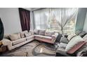 Cozy living room featuring a large corner sofa, patterned rug, and natural light from the window at 3379 S Kirkman Rd # 1027, Orlando, FL 32811