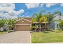 Lovely two-story home with a well-manicured lawn, mature landscaping, and a brick paver driveway at 461 Brunswick Dr, Davenport, FL 33837