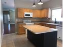 Kitchen with light wood cabinets, stainless steel appliances, and an island with a countertop at 500 Wellesly St, Oviedo, FL 32765
