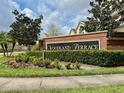 Well maintained entrance sign for Woodland Terrace with lush green landscaping at 506 Terrace Spring Dr, Orlando, FL 32828