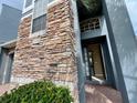 Stylish townhome with a stone facade, an open door, and lush greenery at 506 Terrace Spring Dr, Orlando, FL 32828