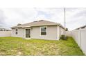 The backyard has wood fence, the exterior is beige and there is a large glass sliding door at 561 Andrea S Cir, Haines City, FL 33844