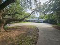Ranch-style home with a large driveway, mature trees, and a carport, blending classic charm with outdoor living at 606 Butler St, Windermere, FL 34786
