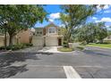 Inviting townhome showcasing a two-car garage, neat landscaping, and a peaceful neighborhood setting at 6453 Alcalde Ct # 110, Orlando, FL 32835