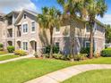 Exterior view of condo with landscaping, sidewalk, lawn, and view of palm trees on a partly cloudy day at 6524 Swissco Dr # 1012, Orlando, FL 32822