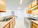 Bright kitchen features white appliances and cabinets with a view to living area at 6524 Swissco Dr # 1012, Orlando, FL 32822