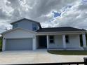 Newly constructed two-story home featuring modern design, a spacious driveway, and a two-car garage at 9122 Trevarthon Rd, Orlando, FL 32817