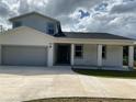 New two-story home with modern design, a spacious driveway, covered porch, and an attached two-car garage at 9122 Trevarthon Rd, Orlando, FL 32817