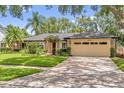 Inviting single-story house with a neat lawn, mature trees, and a two-car garage at 9275 Lake Sharp Ct, Orlando, FL 32817