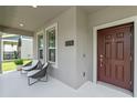 Inviting front porch with stylish seating and a beautifully stained front door at 1378 Roxy Ln, Winter Garden, FL 34787