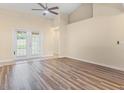 Bright living room with wood floors, ceiling fan, and glass doors leading to the outside at 14322 Pine Cone Trl, Clermont, FL 34711
