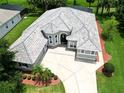 Aerial view of a well-maintained single-story home with a tile roof, lush landscaping, and a wide driveway at 1441 Foxtail Ct, Lake Mary, FL 32746