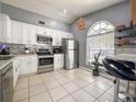 Bright kitchen featuring white cabinetry, stainless steel appliances, granite countertops, and tile flooring at 1470 Daniels Cove Dr, Winter Garden, FL 34787