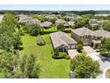 Aerial view showcases a well-maintained home with spacious lawn, mature trees, and pleasing neighborhood at 15500 Fountain Cove Ct, Winter Garden, FL 34787