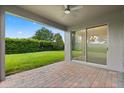 Covered patio with brick flooring, ceiling fan and sliding glass doors to the backyard at 15500 Fountain Cove Ct, Winter Garden, FL 34787