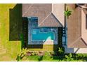 Aerial view of a sparkling pool and patio next to a house with tile roof and green landscaping at 15942 Vetta Dr, Bella Collina, FL 34756
