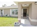 Inviting front porch with welcome sign, lush green lawn, and attractive neutral exterior at 16863 Sw 29Th Terrace Rd, Ocala, FL 34473