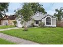 Inviting single-story home featuring a manicured lawn, attached garage, and established landscaping at 1802 Waterbeach Ct, Apopka, FL 32703
