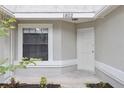 Close up of home's front entrance and the window to the left, painted in neutral color scheme at 1802 Waterbeach Ct, Apopka, FL 32703