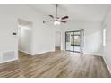 Bright and airy living room featuring wood-look flooring, a ceiling fan, and sliding glass doors at 1802 Waterbeach Ct, Apopka, FL 32703