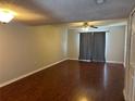Spacious living room with hardwood floors, ceiling fan, and natural light from the large window at 1922 Conway Rd # 1922, Orlando, FL 32812