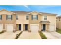 Townhome exterior showcasing individual garages, welcoming entryways, and neatly maintained landscaping at 200 Feltrim Reserve Blvd, Davenport, FL 33837
