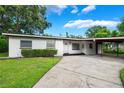 Traditional home with a well-kept lawn, showcasing an inviting carport and front entrance at 209 Wilmer Ave, Orlando, FL 32811