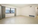 Bright living room featuring neutral walls, terrazzo flooring, and a large window with views of the neighborhood at 2417 Bayfront Pkwy, Orlando, FL 32806