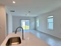 Bright and airy living room featuring neutral tones, tiled floors, and sliding glass doors to the yard at 2739 San Marco Way, Winter Haven, FL 33884