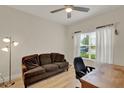 Comfortable bedroom with wood-look tile flooring, a ceiling fan and a bright window with sheer white curtains at 3210 Sonesta Ct # B, Clermont, FL 34711