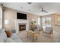 Cozy living room with a fireplace, comfortable seating, a ceiling fan, and a view of the pool area at 3808 Ocita Dr, Orlando, FL 32837