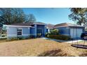 Home exterior featuring mature shrubbery, shade tree and two car garage at 3917 Derby Dr, Lakeland, FL 33809
