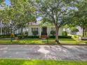Beautifully landscaped home exterior featuring manicured greenery, stately trees, and a charming facade under a bright, sunny sky at 4545 Fox St, Orlando, FL 32814
