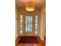 Inviting entryway with a striking light fixture, glass-paneled door, sidelights, and a decorative rug at 501 Richmond St, Orlando, FL 32806