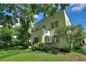 Lovely two-story house with mature trees and landscaping, featuring a charming front porch and a well-manicured lawn at 501 Richmond St, Orlando, FL 32806
