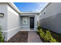 Inviting home entrance with a brick pathway, decorative plants, and a stylish black front door at 5029 Grand Teton Ct, Deland, FL 32724